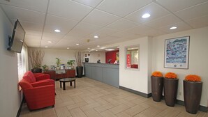 A reception area with a counter, seating, and decorative vases. - Americas Best Value Inn Pilot Mountain (Pilot Mountain)