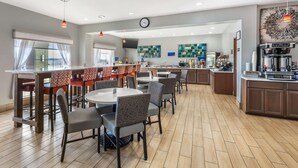A modern hotel lobby with a bar area, dining tables, and chairs. - Best Western Club House Inn & Suites (Mineral Wells)