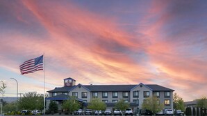 A hotel with a flat roof, multiple windows, and a sign indicating it is a Best Western Plus.