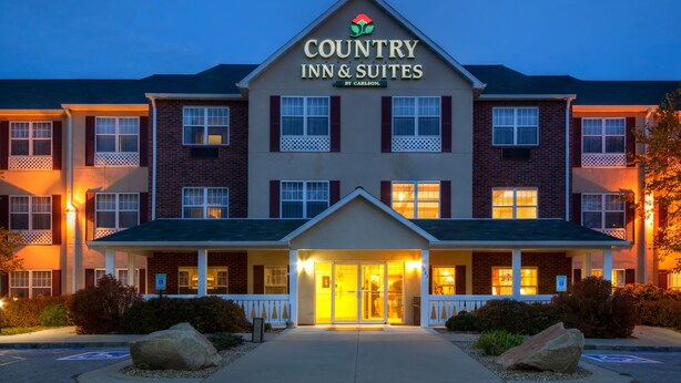A Country Inn & Suites building with a prominent sign, multiple windows, and a well-lit entrance. - Country Inn & Suites by Radisson, Mason City, IA (Mason City)