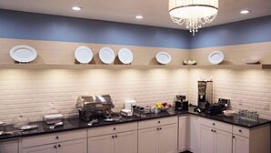 A modern kitchen with white cabinets, a black countertop, and a chandelier. - Country Inn & Suites by Radisson, Frackville (Pottsville), PA (Pottsville)