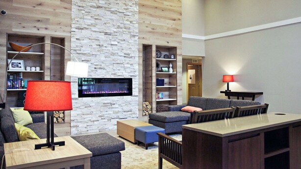 A modern living room with a fireplace, built-in shelves, and a cozy seating area. - Country Inn & Suites by Radisson, Frackville (Pottsville), PA (Pottsville)