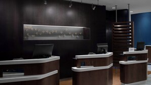 A reception area with dark wood reception desks, a wall-mounted display with hanging items, and a blue accent wall.