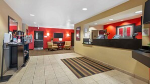 A hotel lobby with a reception desk, seating area, and a coffee station. - Extended Stay America Suites Secaucus Meadowlands (Secaucus)