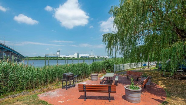 A lakeside park with a bench, picnic table, grill, and potted plants. - Extended Stay America Suites Secaucus Meadowlands (Secaucus)