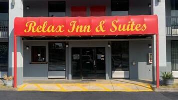 A building with a sign reading 'Relax Inn & Suites' and a red awning.