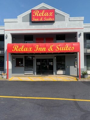Un edificio con un letrero que dice 'Relax Inn & Suites' y un toldo rojo.