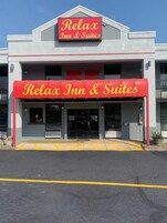 Un edificio con un letrero que dice 'Relax Inn & Suites' y un toldo rojo.