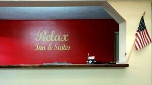 A red wall with the text "Relax Inn & Suites" and two American flags on either side. - Relax Inn & Suites (Dublin)