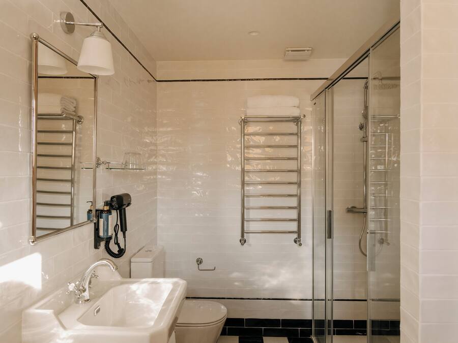 A modern bathroom with a glass shower enclosure, a built-in toilet, and a sink with a mirror.