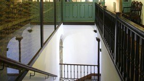A spacious interior with a high ceiling, green-painted walls, and a polished floor. - Hotel PAX Casona del Busto (Pravia)