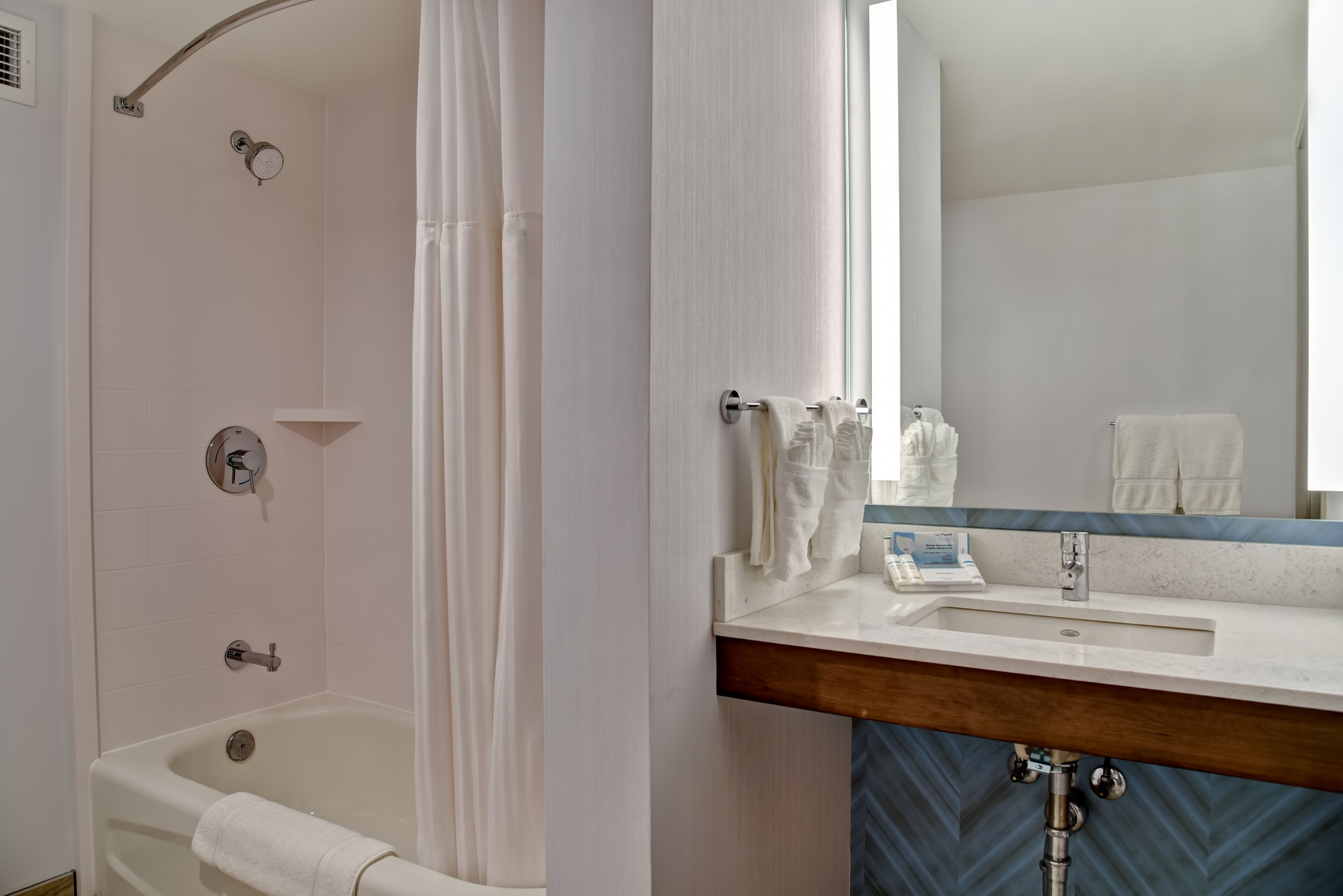 Une salle de bain avec une baignoire, un lavabo et un miroir.