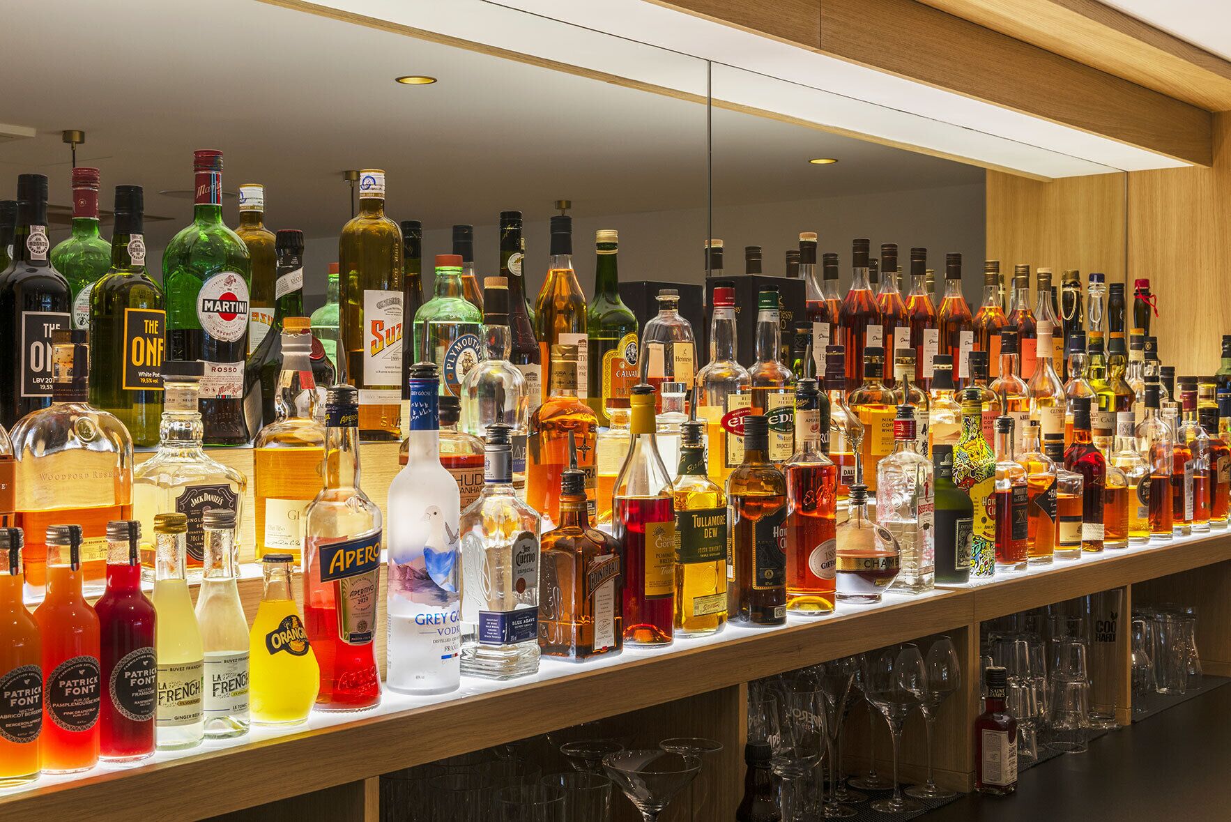 A bar area with a variety of liquor bottles and glasses.