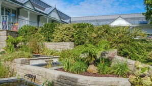 A garden with a pond, stone walls, and various plants. - Domaine du Limonay, The Originals Collection (Saint-Meloir-des-Ondes)
