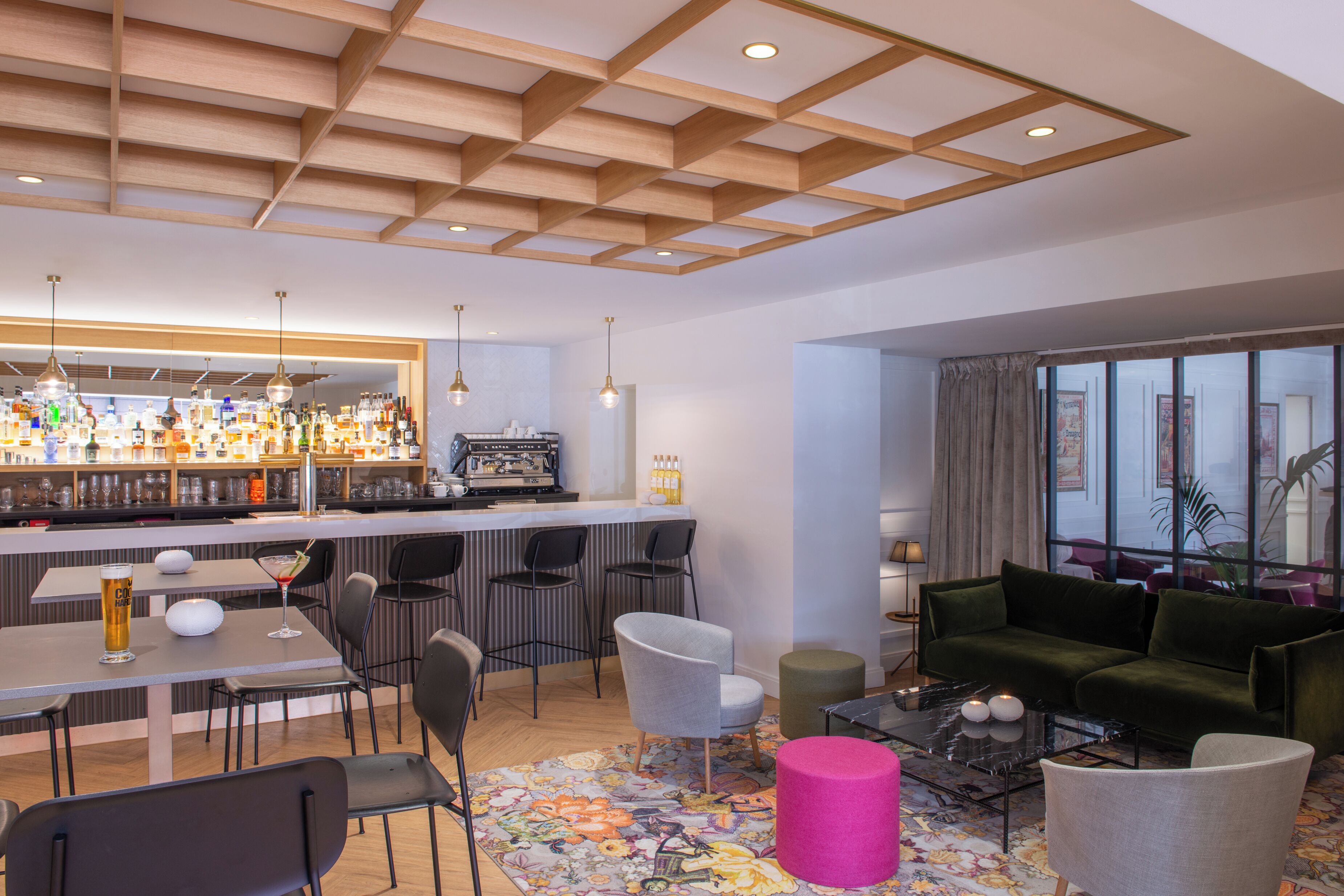 Eine moderne Bar mit Theke, Sitzgelegenheiten und einer Auswahl an Flaschen.