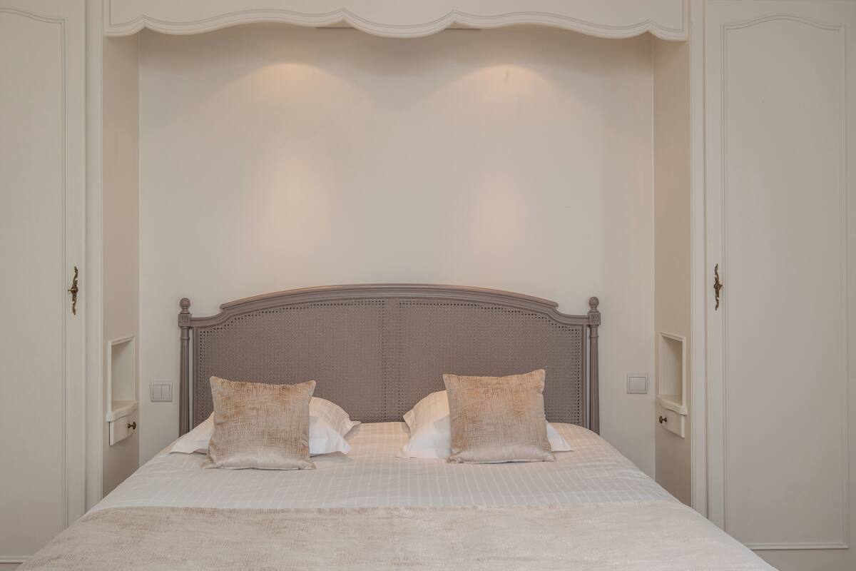 A bedroom with a large bed, two pillows, and a headboard.