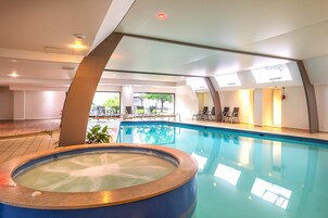 Una piscina techada, sillones reclinables de piscina