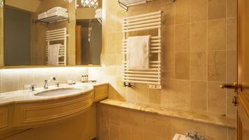 A bathroom with a sink, mirror, towel racks, and a bathtub.