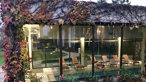 A glass-enclosed lounge area with outdoor seating and a view of a landscaped garden. - Château de Sancy (Sancy)