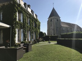 A building with ivy-covered walls and a tower with a clock.