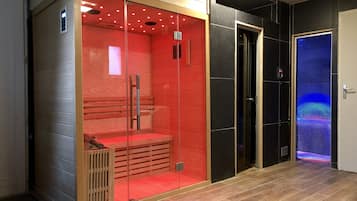 A modern room with a glass enclosure, a wooden bench, and a door with a blue light.