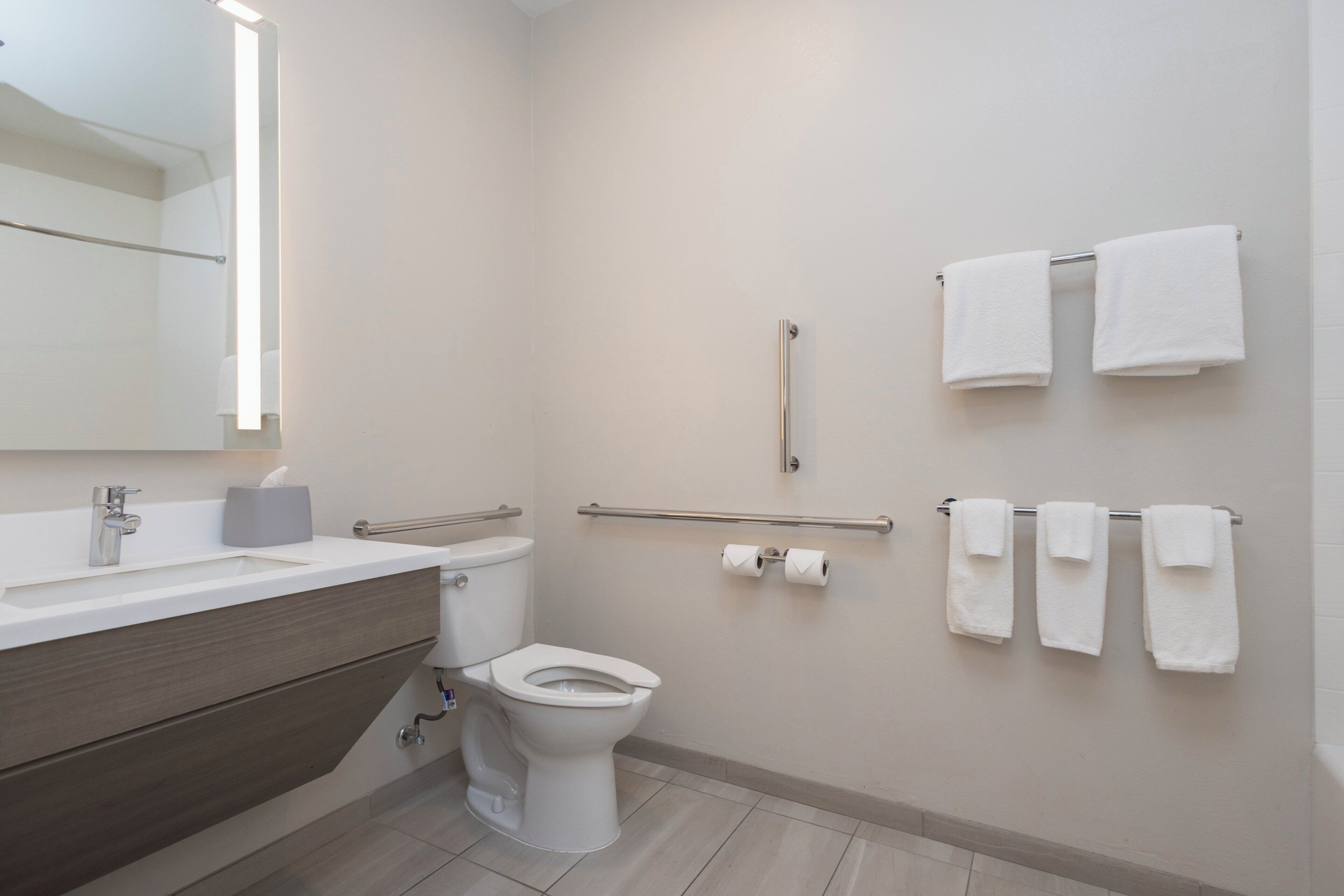 Un baño moderno con inodoro, lavamanos y toallero.