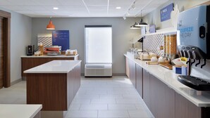 Une cuisine moderne avec un îlot central, une grande fenêtre et une machine à café.