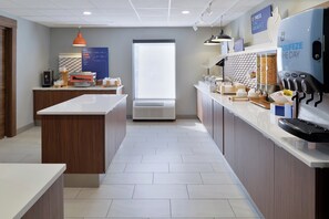 Une cuisine moderne avec un îlot central, une grande fenêtre et une machine à café.