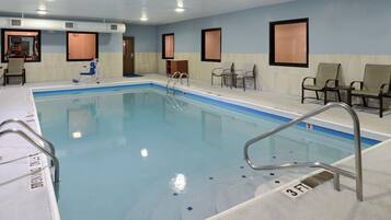 Una piscina con indicador de profundidad de 90 centímetros, rodeada de sillas y un vestuario.