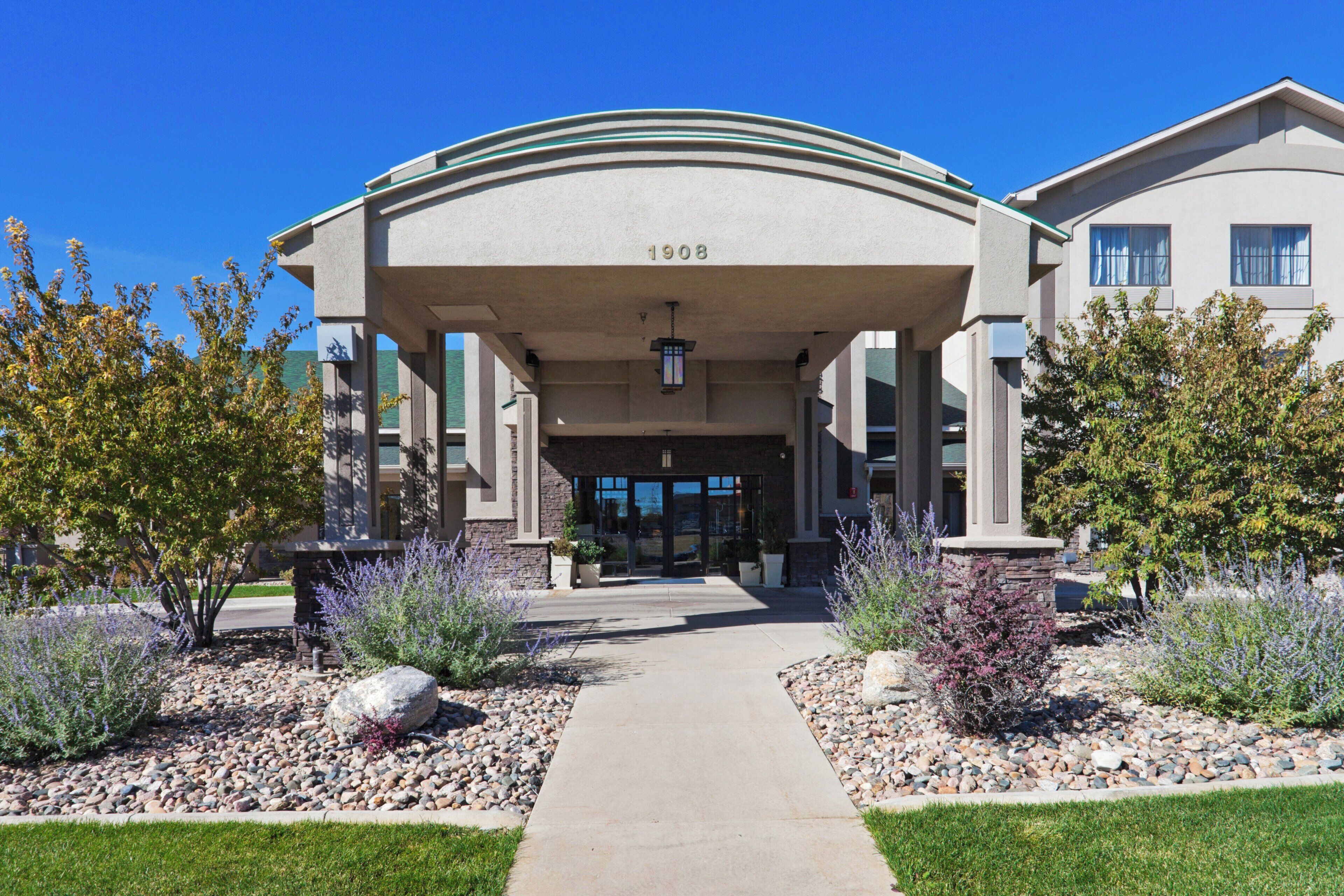 A building with a covered entrance, numbered 1908, and a pathway leading to the entrance.