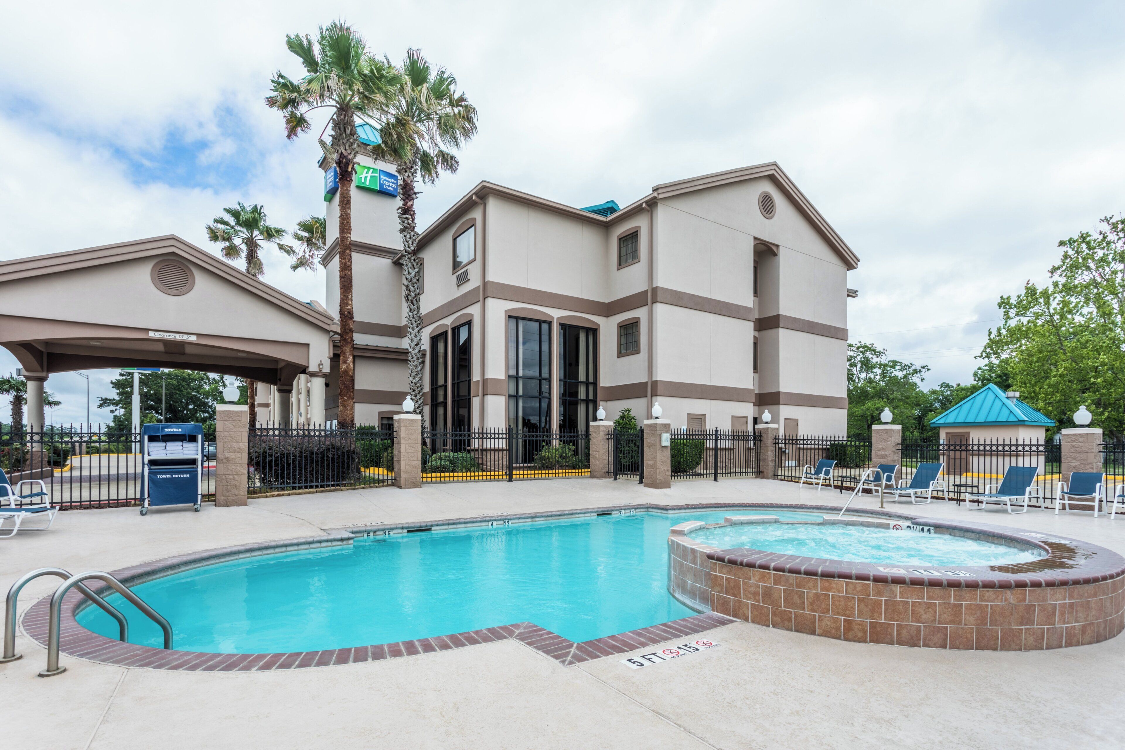 A hotel with a swimming pool, a covered area, and a sign for a nearby Express location.
