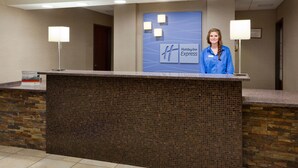 Taulell de recepció d'Holiday Inn Express amb un mur de mosaic encaratellat, dues làmpades penjades a la paret i un quadre emmarcat.