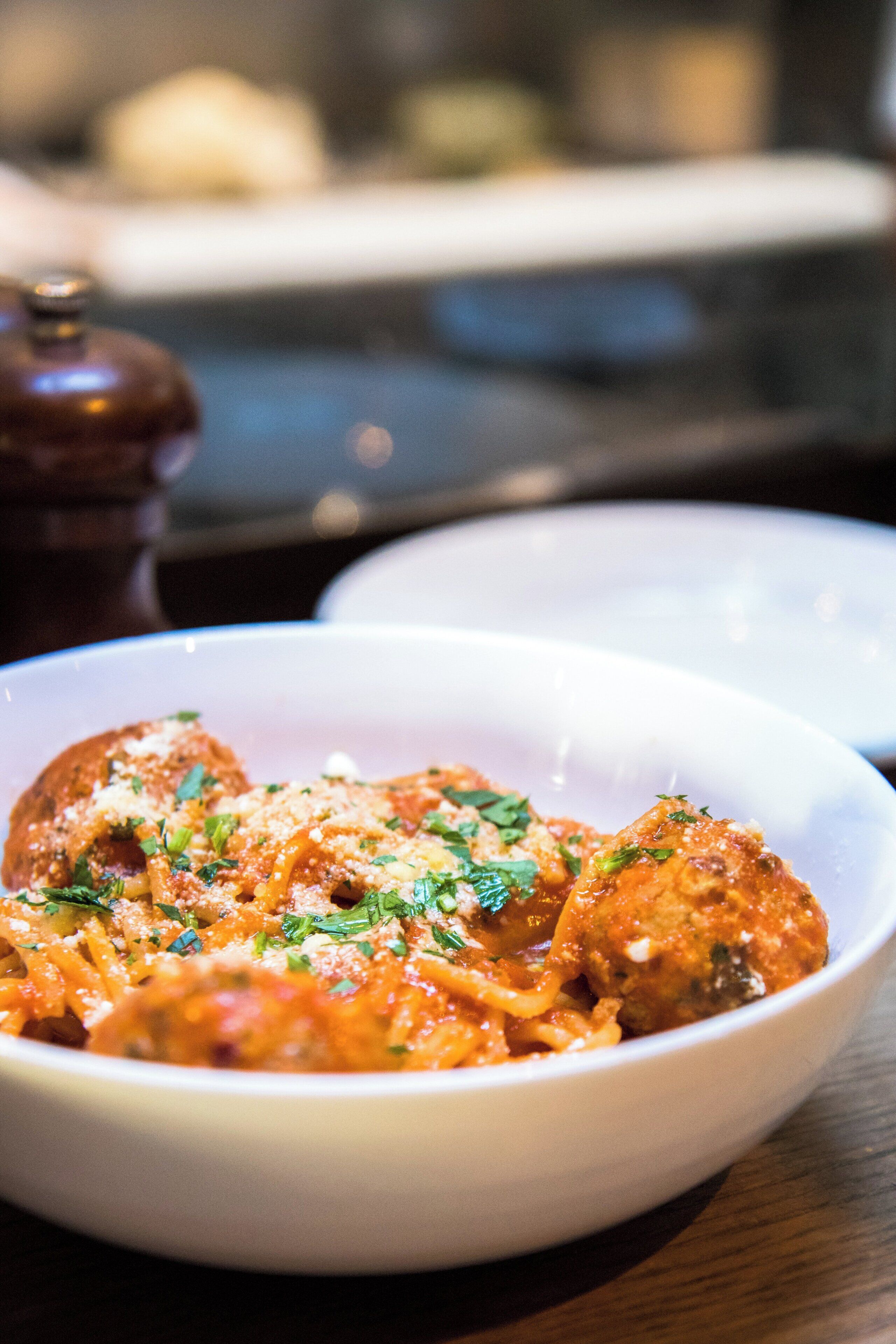 A bowl of pasta with a tomato-based sauce, garnished with herbs.