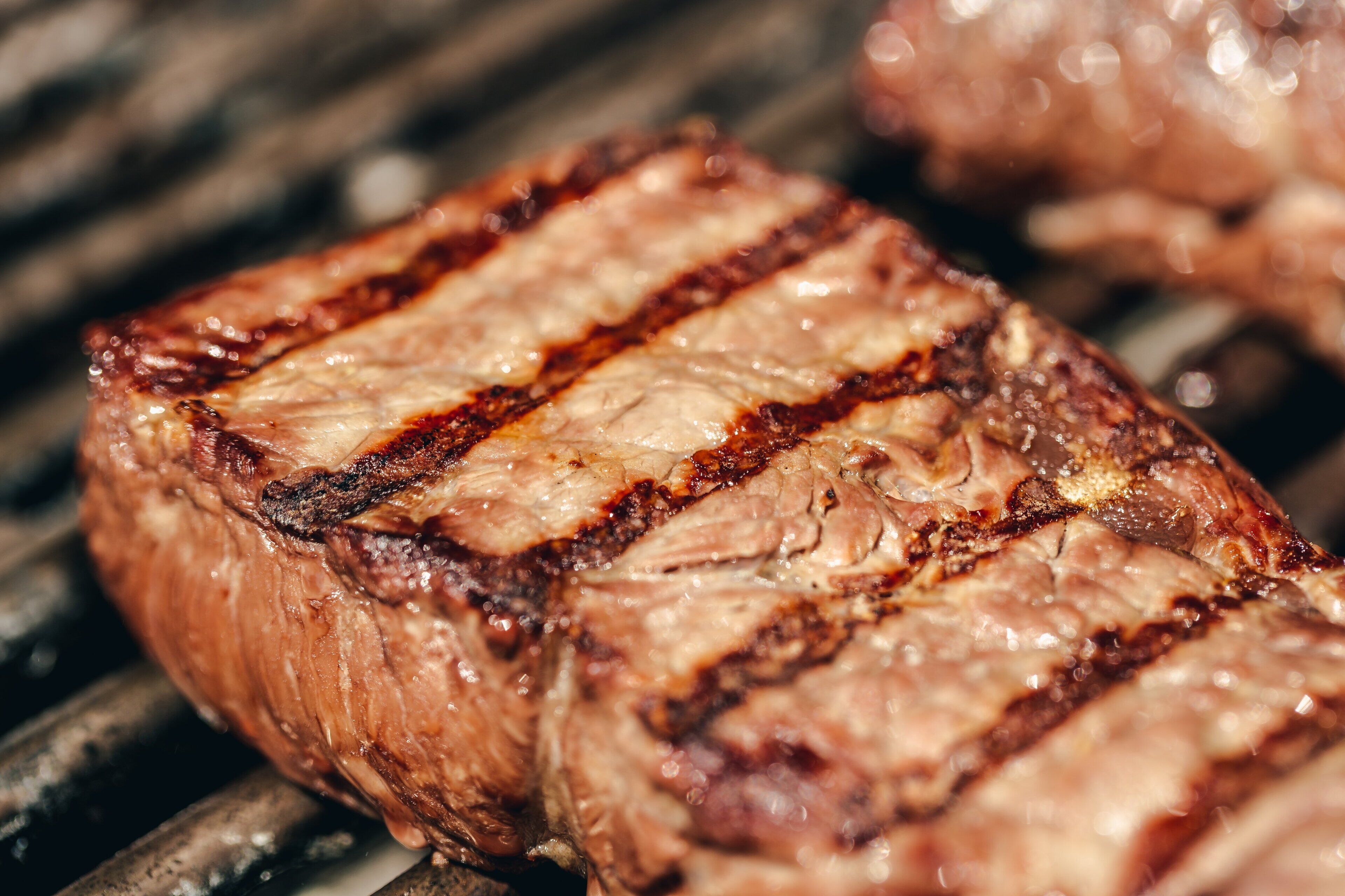 Primer plano de un bistec a la parrilla con marcas visibles de la parrilla.