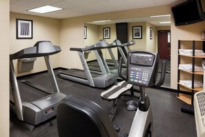 A fitness center with treadmills, elliptical machines, and a rowing machine.
