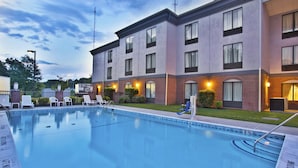 A hotel with a swimming pool, lounge chairs, and a brick facade. - Holiday Inn Express Hotel & Suites Harrington-Dover area, DE by IHG (Harrington)