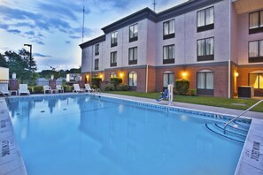 A hotel with a swimming pool, lounge chairs, and a brick facade. - Holiday Inn Express Hotel & Suites Harrington-Dover area, DE by IHG (Harrington)