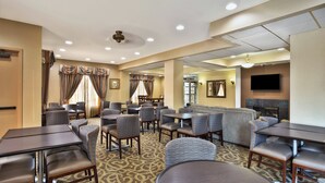 A hotel lobby with seating areas, a fireplace, and a television. - Holiday Inn Express Hotel & Suites Harrington-Dover area, DE by IHG (Harrington)