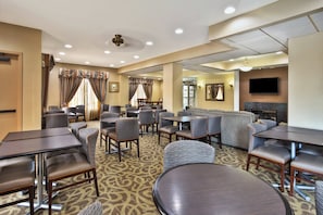 A hotel lobby with seating areas, a fireplace, and a television. - Holiday Inn Express Hotel & Suites Harrington-Dover area, DE by IHG (Harrington)