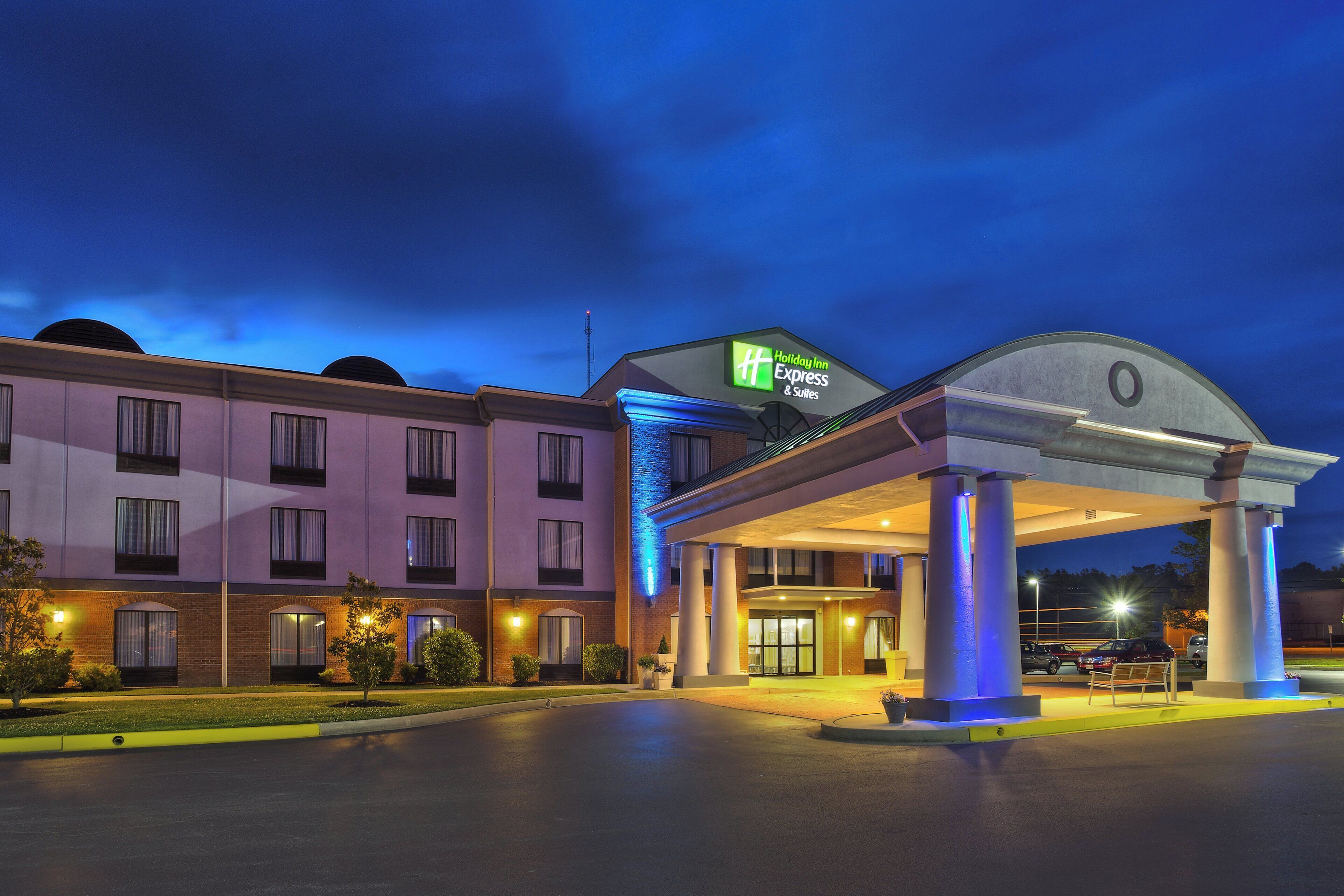 A Holiday Inn Express & Suites hotel with a covered entrance and a parking lot.
