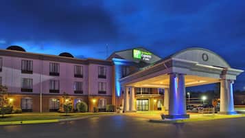 A Holiday Inn Express & Suites hotel with a covered entrance and a parking lot.