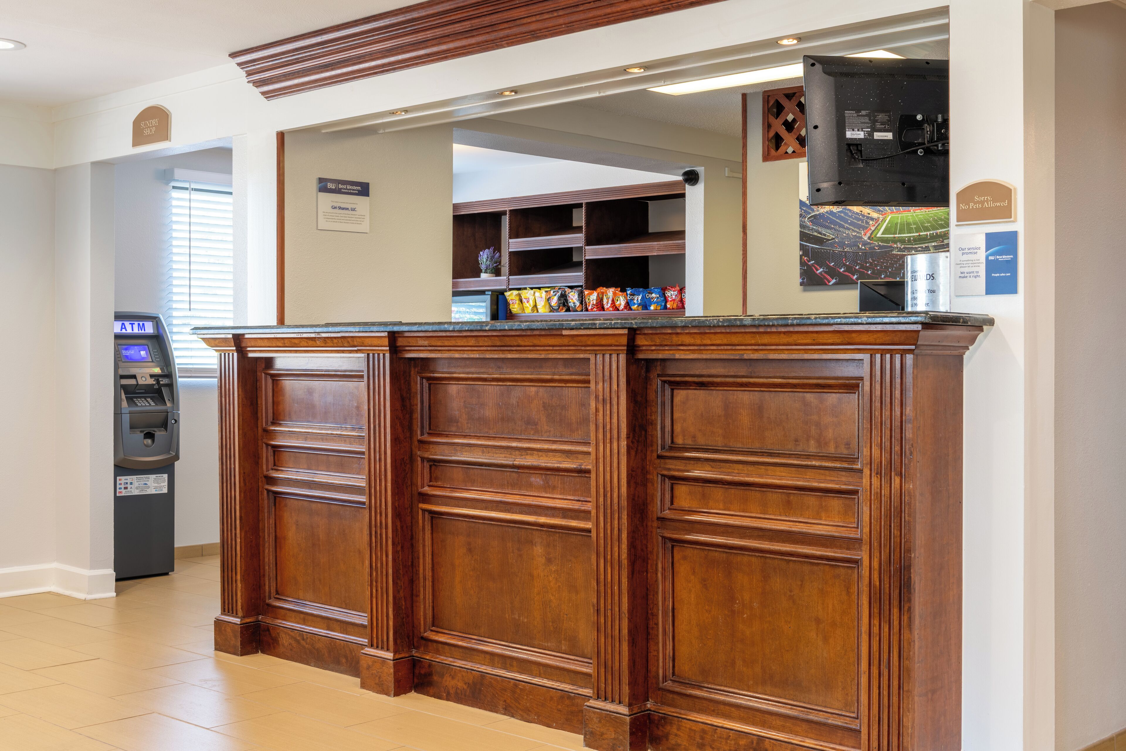 A reception area with a wooden reception desk, an ATM, and a sports memorabilia display.