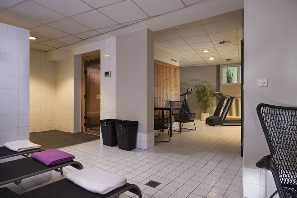 A clean, modern waiting area with a reception desk, seating, and a staircase leading to an upper floor.