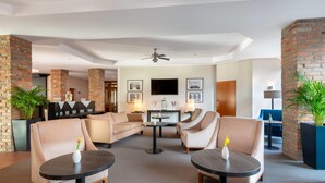 A modern lounge area with a sofa, two armchairs, and a coffee table, featuring a flat-screen TV and framed pictures on the wall. - greet Hotel Potsdam am Park Sanssouci (frisch renoviert) (Potsdam)