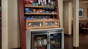 A snack display with various treats and a refrigerated beverage cooler.
