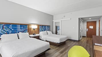 Een hotelkamer met twee bedden, een bureau, een stoel en een deur.