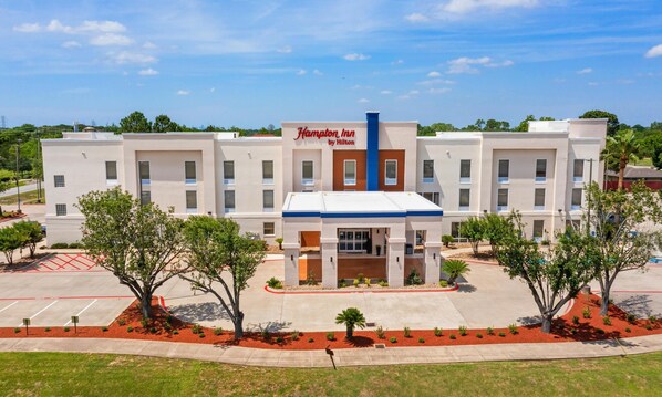 A Hampton Inn by Hilton with a central entrance, multiple floors, and a parking lot. - Hampton Inn Houston-Pearland (Pearland)