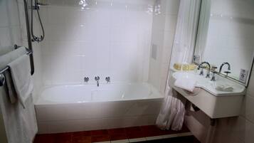 A bathroom with a bathtub, a sink, and a shower.