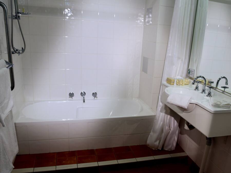 A bathroom with a bathtub, a sink, and a shower.