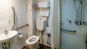 A bathroom with a toilet, sink, and shower area.